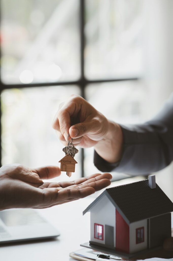 A home rental company employee is handing the house keys.